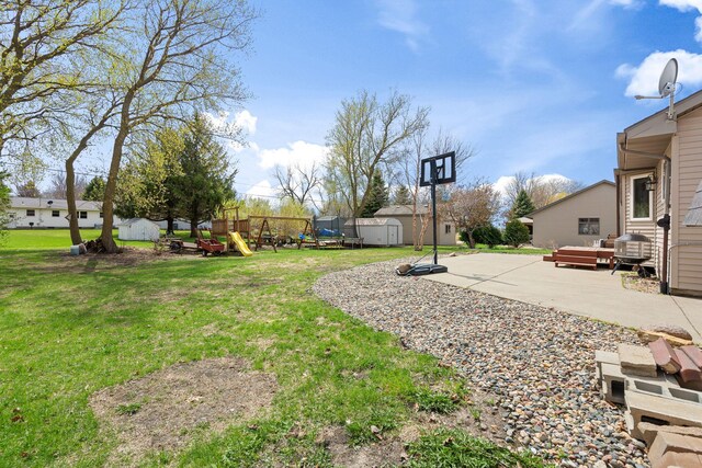 404 6th St NW, New Richland, MN 56072 - view of green lawn with a storage shed, a playground, an outdoor structure, and a patio