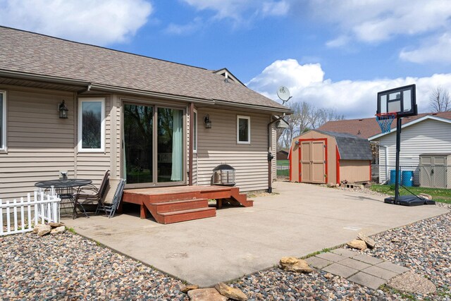 404 6th St NW, New Richland, MN 56072 - rear view of house featuring a storage unit, a patio, and roof with shingles