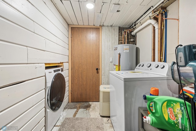 laundry room featuring laundry area, independent washer and dryer, wooden walls, and water heater
