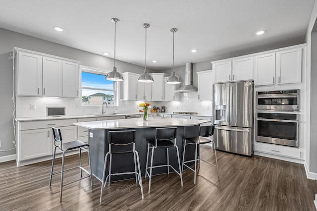 825 Spancil Hill Vw, Woodbury, MN 55129 - kitchen with stainless steel appliances, wall chimney range hood, a sink, a center island, and white cabinetry