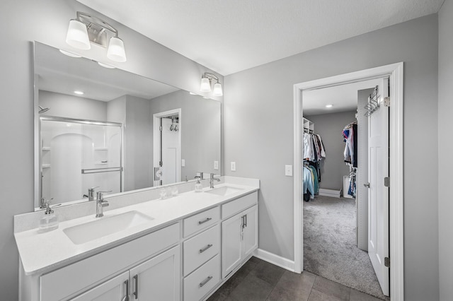 825 Spancil Hill Vw, Woodbury, MN 55129 - full bathroom with double vanity, a spacious closet, a shower, baseboards, and tile patterned flooring