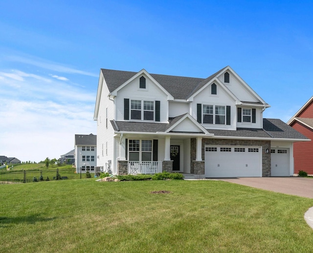 825 Spancil Hill Vw, Woodbury, MN 55129 - view of front of house with covered porch, driveway, a garage, stone siding, and a shingled roof