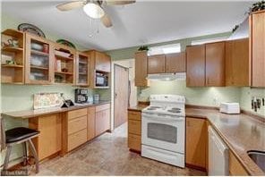 20 Windsor Ln Unit 303A, New Brighton, MN 55112 - kitchen with white electric range oven, range hood, a ceiling fan, dishwashing machine, and glass insert cabinets