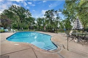 20 Windsor Ln Unit 303A, New Brighton, MN 55112 - outdoor pool with a patio and view of wooded area