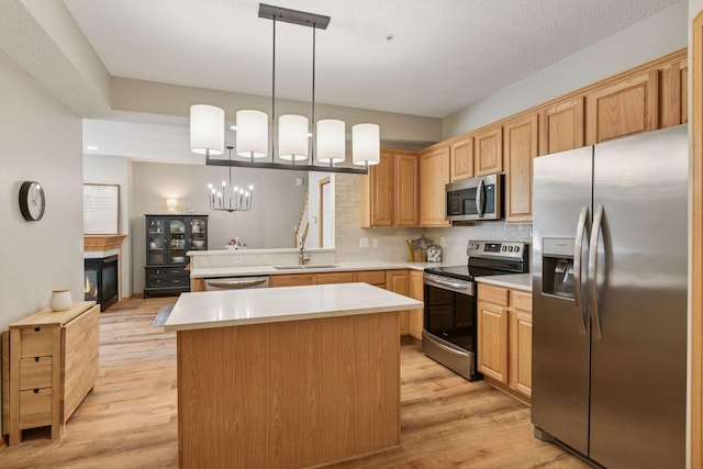 13700 54th Ave N Unit 405, Plymouth, MN 55446 - kitchen featuring stainless steel appliances, a sink, a peninsula, light wood finished floors, and light countertops