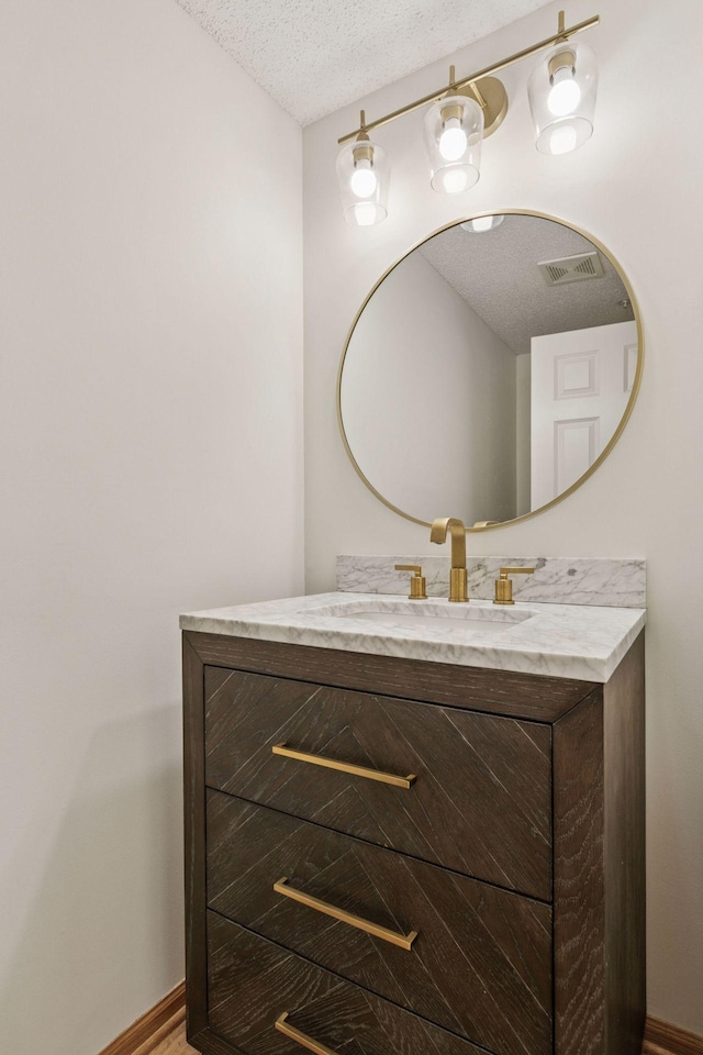 13700 54th Ave N Unit 405, Plymouth, MN 55446 - bathroom featuring a textured ceiling, vanity, and baseboards