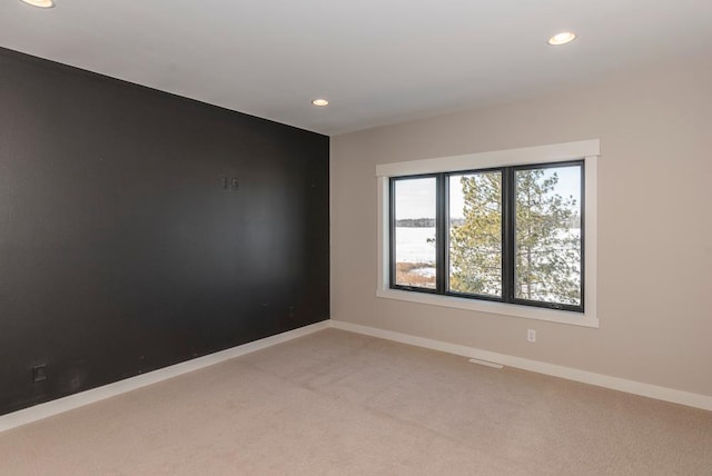 unfurnished room with recessed lighting, light colored carpet, and baseboards