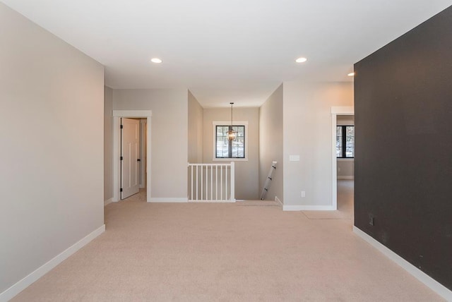unfurnished room with baseboards, plenty of natural light, light colored carpet, and recessed lighting