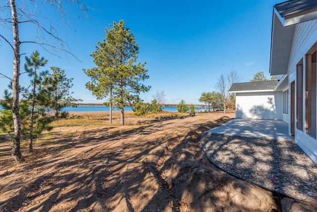 view of yard featuring a patio area and a water view