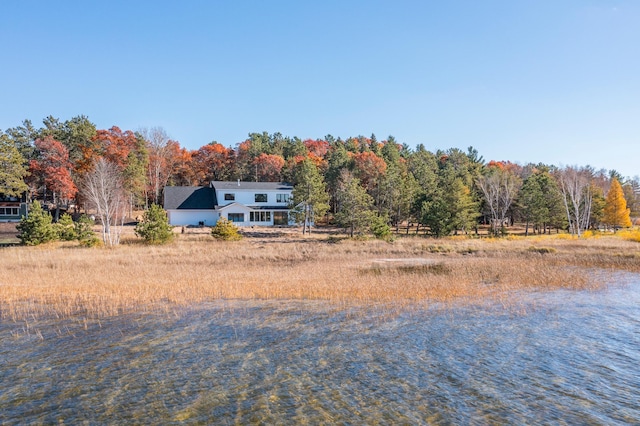 view of front of property featuring a view of trees