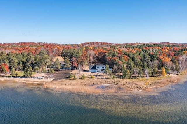 aerial view of property and surrounding area featuring a forest and a large body of water