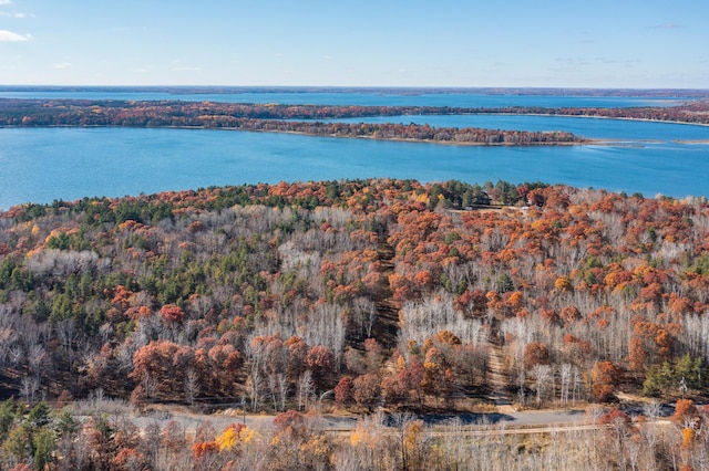 aerial view of property and surrounding area with a forest and a large body of water
