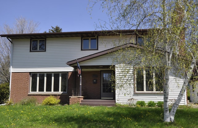 traditional home featuring brick siding and a front lawn