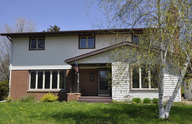 669 14th St, Saint Charles, MN 55972 - traditional home featuring brick siding and a front lawn