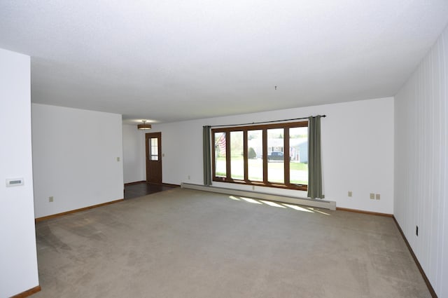 carpeted spare room with baseboards and baseboard heating