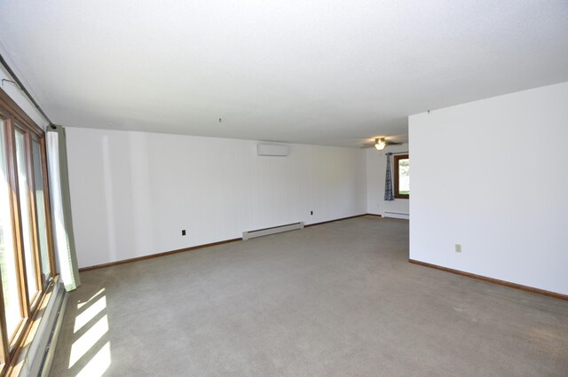 carpeted empty room with baseboard heating, ceiling fan, baseboards, and a wall mounted air conditioner