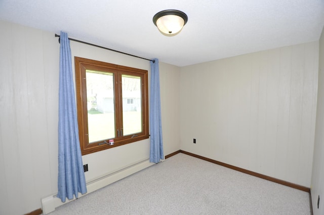 carpeted empty room with baseboard heating and baseboards