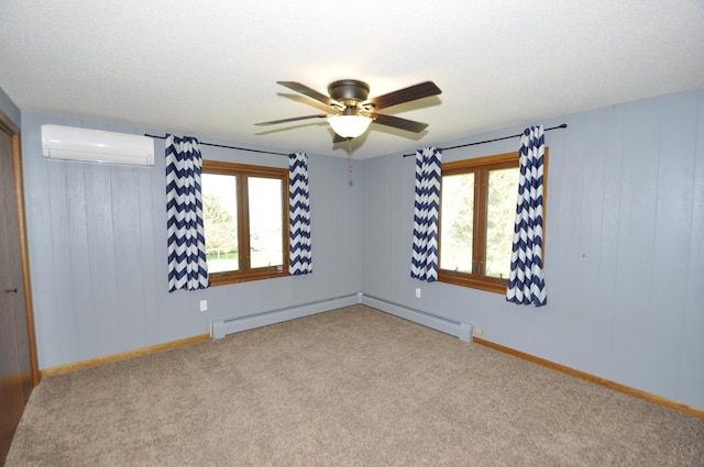 carpeted empty room with a ceiling fan, baseboards, a wall mounted air conditioner, and plenty of natural light