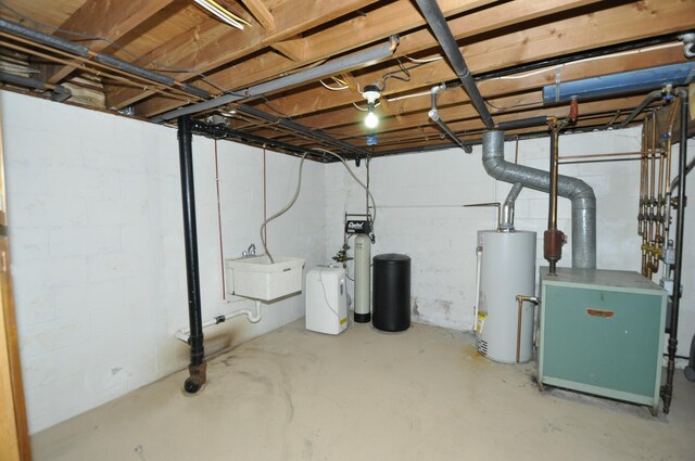 unfinished basement featuring water heater, a sink, a heating unit, concrete block wall, and a water softener