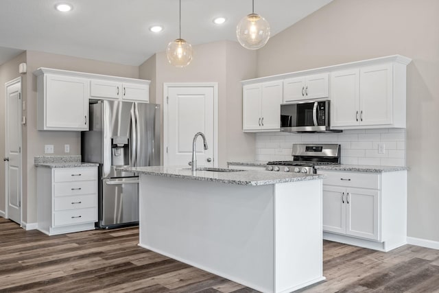 kitchen featuring appliances with stainless steel finishes, a sink, backsplash, white cabinets, and dark wood-style flooring