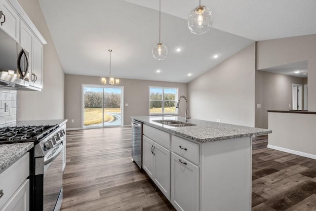 kitchen with a sink, stainless steel appliances, vaulted ceiling, dark wood-style floors, and a center island with sink
