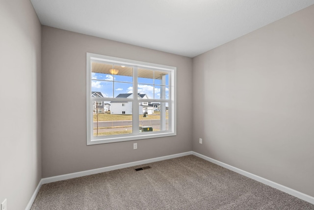 carpeted spare room featuring baseboards