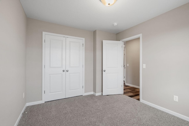 unfurnished bedroom with carpet flooring, baseboards, and a closet