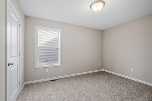 empty room featuring carpet flooring and baseboards