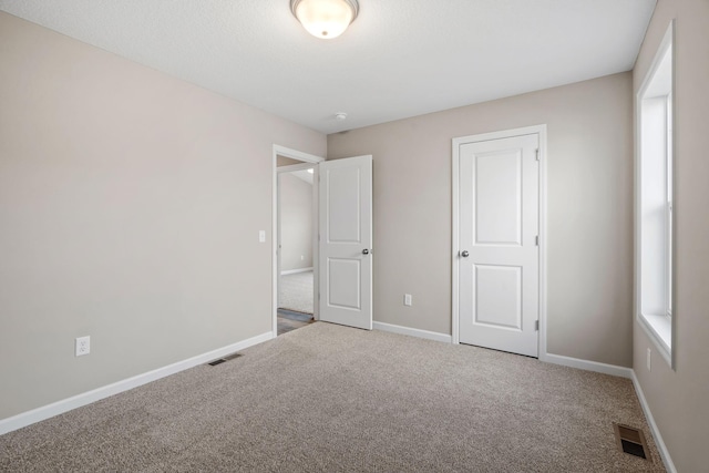 unfurnished bedroom featuring carpet and baseboards