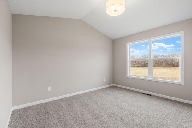 carpeted spare room with lofted ceiling and baseboards