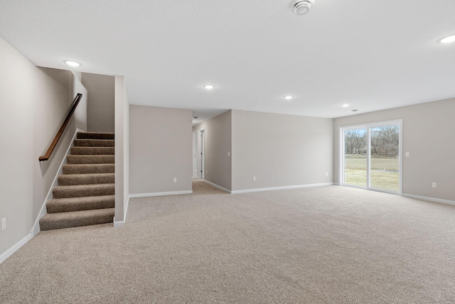 unfurnished living room with baseboards, carpet floors, stairs, and recessed lighting