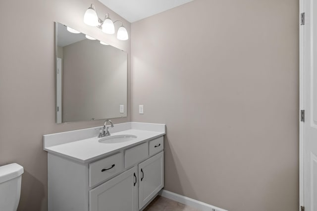 half bathroom with toilet, vanity, and baseboards