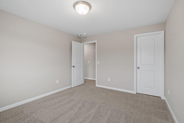 unfurnished bedroom featuring carpet and baseboards