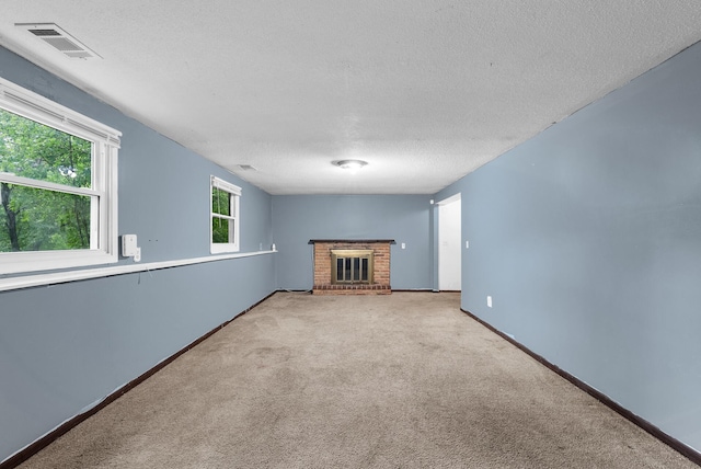 4209 81st Ave N, Brooklyn Park, MN 55443 - unfurnished living room featuring a textured ceiling, a brick fireplace, carpet flooring, and baseboards