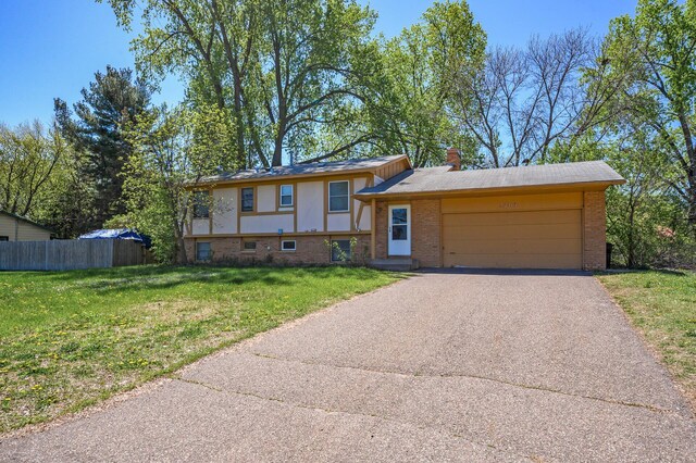 4209 81st Ave N, Brooklyn Park, MN 55443 - view of front facade featuring an attached garage, brick siding, asphalt driveway, and a chimney
