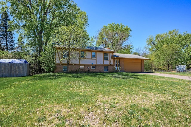 4209 81st Ave N, Brooklyn Park, MN 55443 - view of front of house featuring an attached garage, driveway, brick siding, and a front lawn