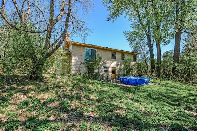 4209 81st Ave N, Brooklyn Park, MN 55443 - back of house with a chimney, an outdoor pool, and a yard