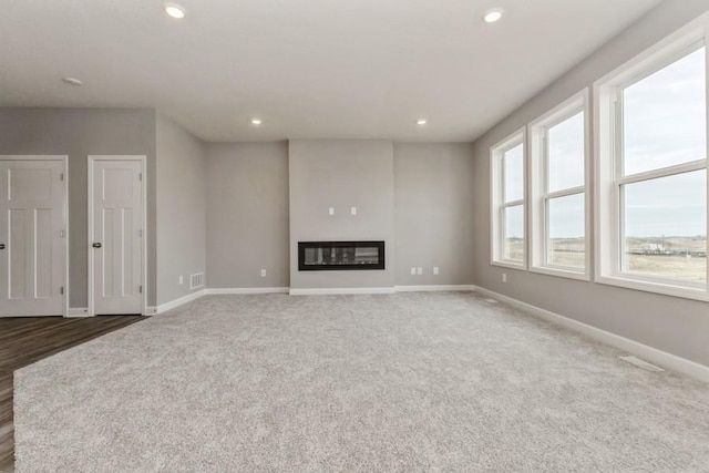 2466 Jandell Ave NE, Saint Michael, MN 55376 - unfurnished living room featuring baseboards, recessed lighting, carpet, and a glass covered fireplace