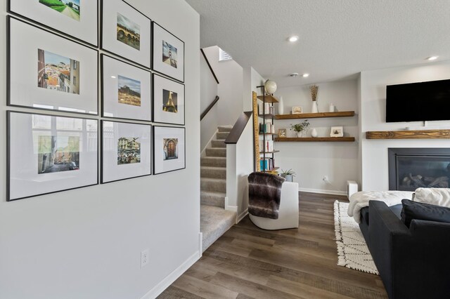 living room with stairs, wood finished floors, baseboards, recessed lighting, and a textured ceiling