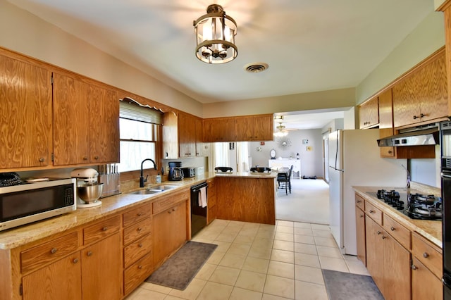 kitchen featuring under cabinet range hood, visible vents, a sink, black appliances, and light countertops