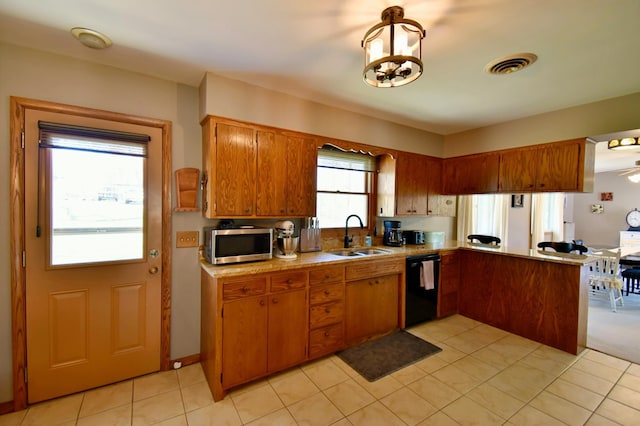kitchen featuring dishwasher, visible vents, stainless steel microwave, a sink, and brown cabinets