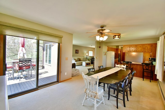 dining room featuring a baseboard heating unit, a ceiling fan, and light colored carpet