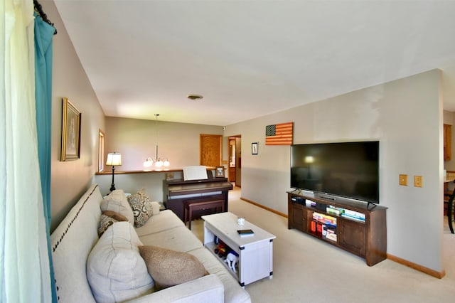living room with baseboards, a notable chandelier, and light carpet
