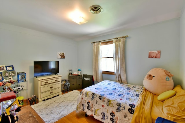 bedroom with visible vents and wood finished floors