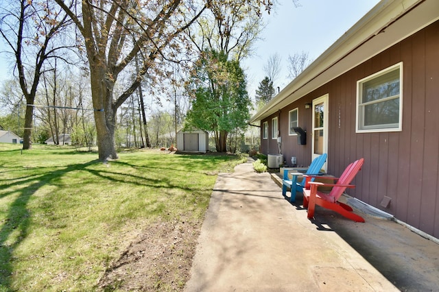 view of yard featuring a storage shed, a patio, an outbuilding, and central AC