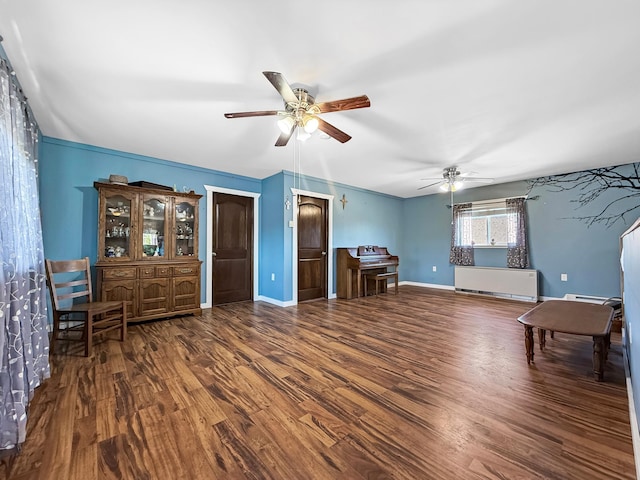 living area featuring wood finished floors, ceiling fan, and baseboards