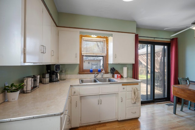 5748 25th Ave S, Minneapolis, MN 55417 - kitchen with white cabinets, light countertops, light wood finished floors, and a sink