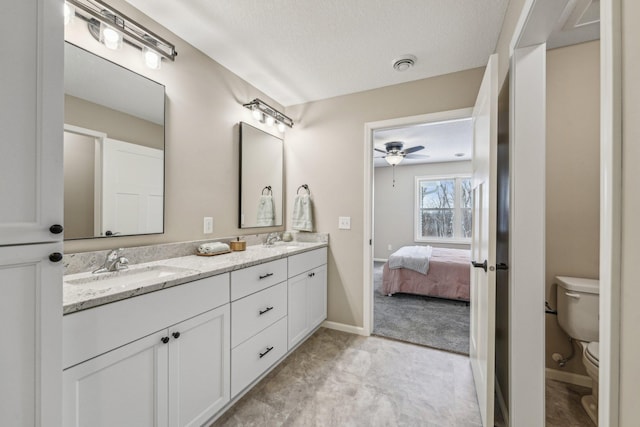20106 Fitzgerald Trl N, Forest Lake, MN 55025 - ensuite bathroom featuring a ceiling fan, toilet, double vanity, baseboards, and a textured ceiling