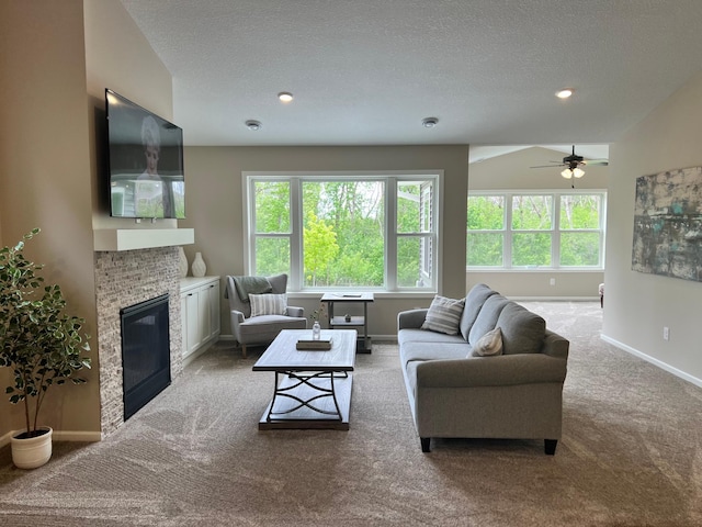 20106 Fitzgerald Trl N, Forest Lake, MN 55025 - living room with light carpet, baseboards, a glass covered fireplace, a textured ceiling, and a ceiling fan