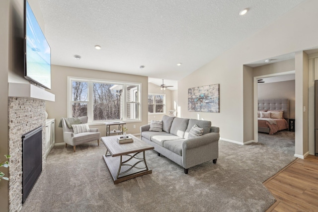 20106 Fitzgerald Trl N, Forest Lake, MN 55025 - carpeted living area with a fireplace, lofted ceiling, a textured ceiling, wood finished floors, and baseboards